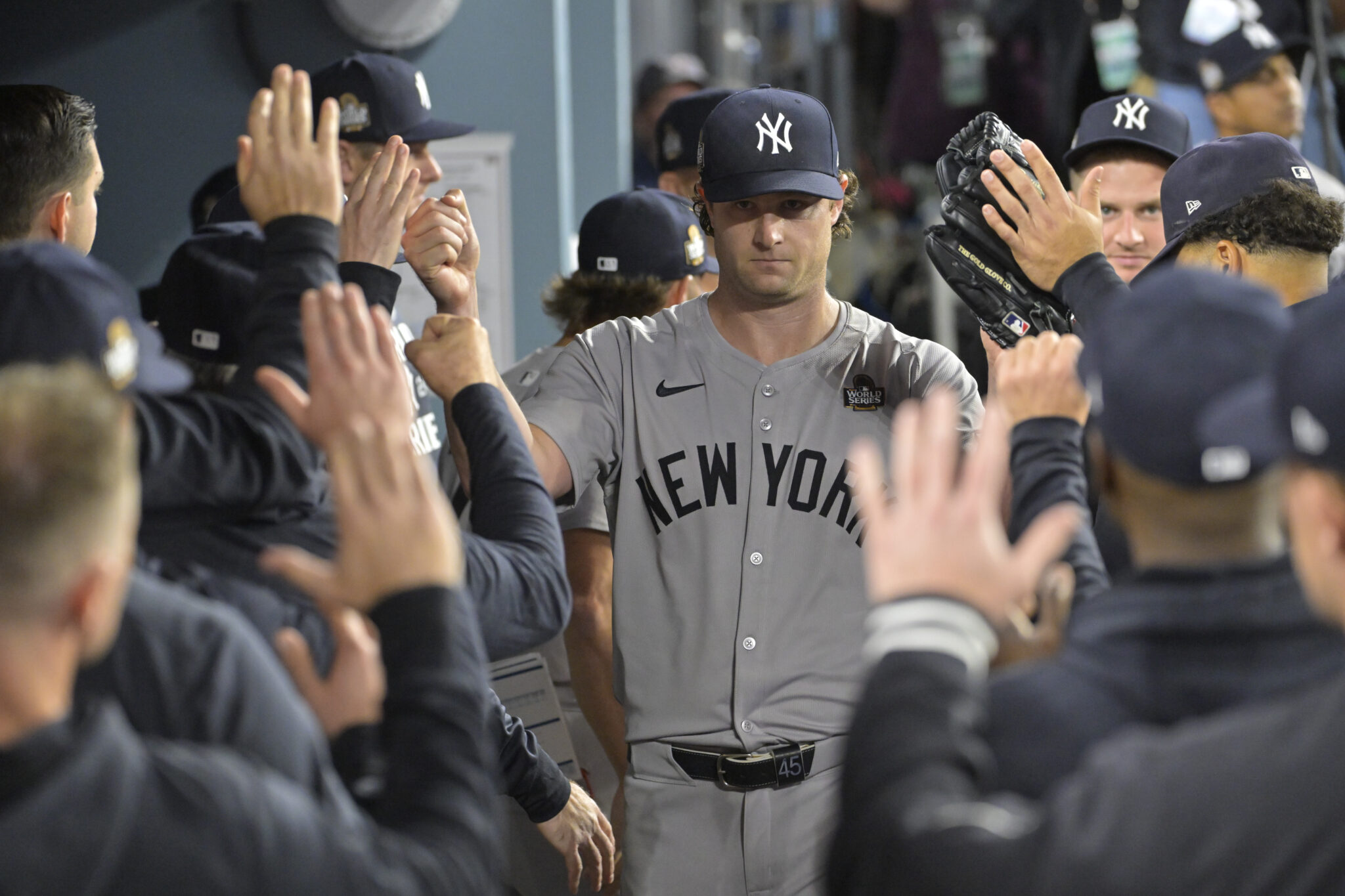 Oct 25, 2024; Los Angeles, California, USA; New York Yankees starting pitcher Gerrit Cole (45) receives congratulations in the dugout in the seventh inning against the Los Angeles Dodgers during game one of the 2024 MLB World Series at Dodger Stadium.