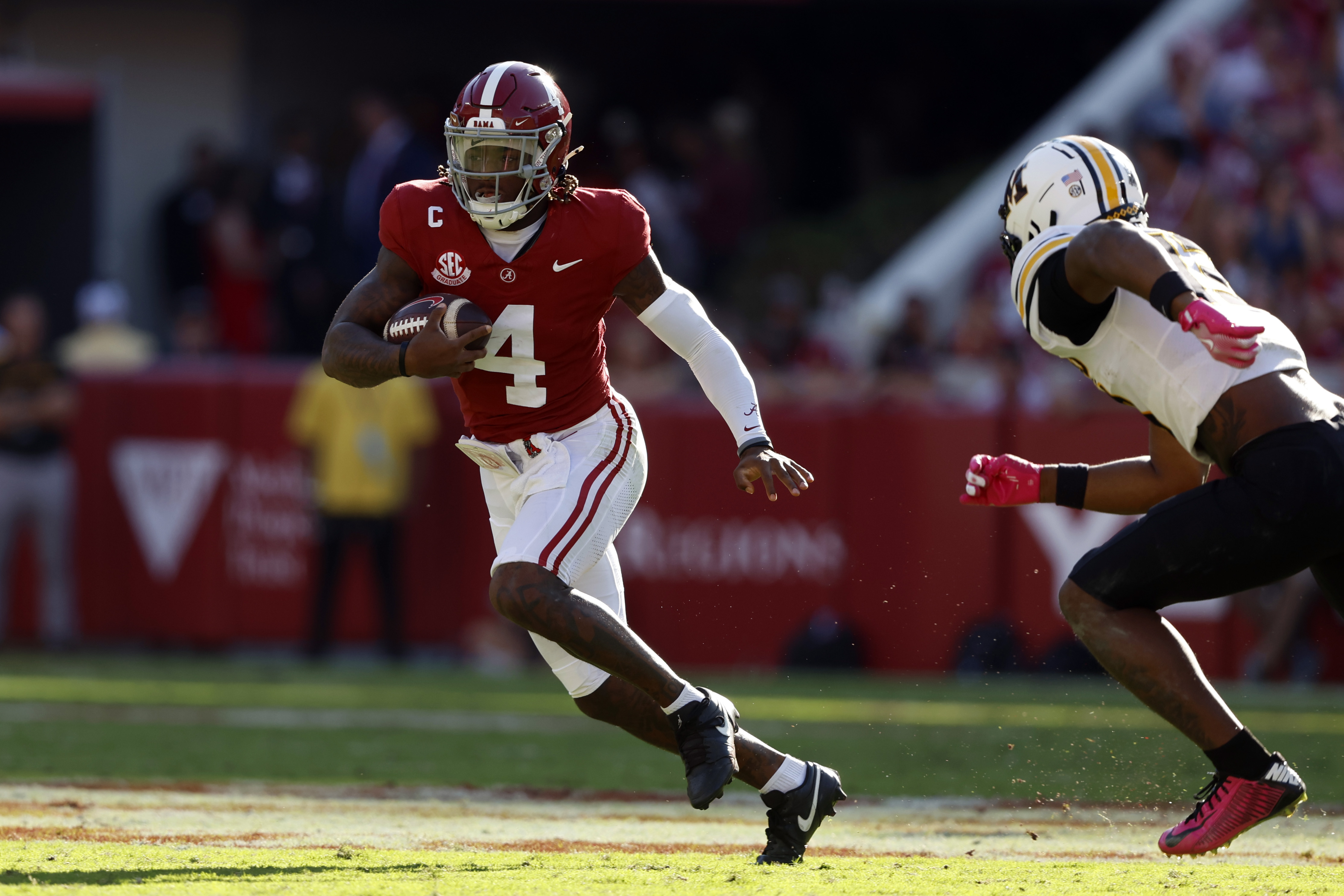 Oct 26, 2024; Tuscaloosa, Alabama, USA; Alabama Crimson Tide quarterback Jalen Milroe (4) scrambles around Missouri Tigers cornerback Toriano Pride Jr. (2) for a first down during the first half at Bryant-Denny Stadium.