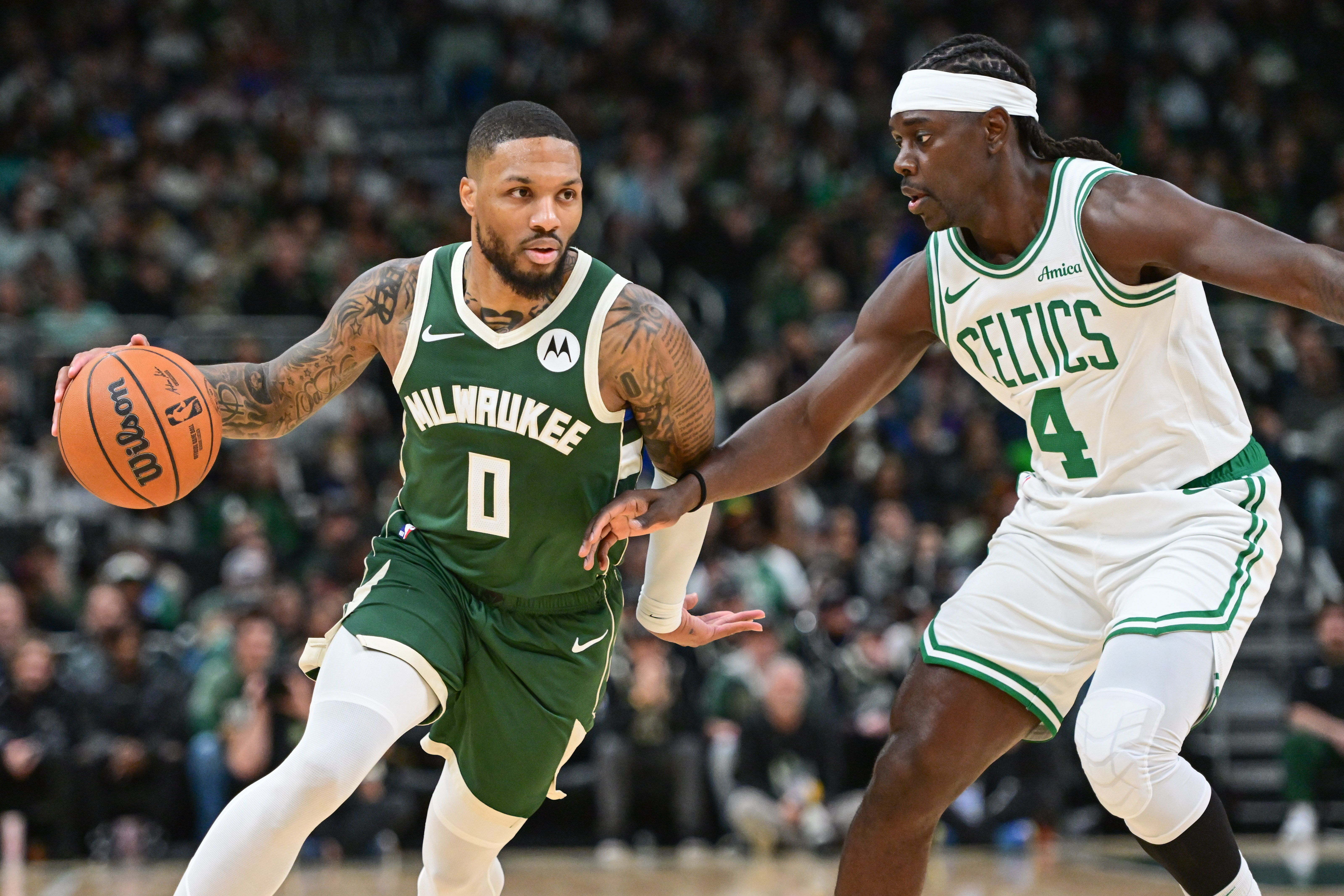 Nov 10, 2024; Milwaukee, Wisconsin, USA; Milwaukee Bucks guard Damian Lillard (0) drives for the basket against Boston Celtics guard Jrue Holiday (4) in the first quarter at Fiserv Forum.