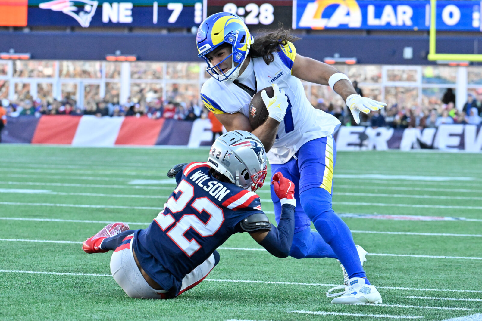 Nov 17, 2024; Foxborough, Massachusetts, USA; New England Patriots cornerback Marco Wilson (22) tries to tackle Los Angeles Rams wide receiver Puka Nacua (17) during the first half at Gillette Stadium.