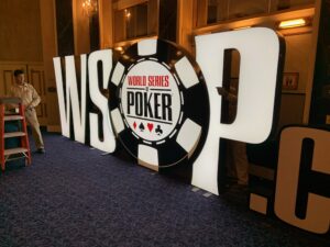 Workers install the World Series of Poker logo at the Paris Las Vegas convention center on Thursday, May 26, 2022.